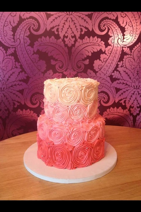 Bolo de aniversário impressionante coberto com glacé rosa e rosas